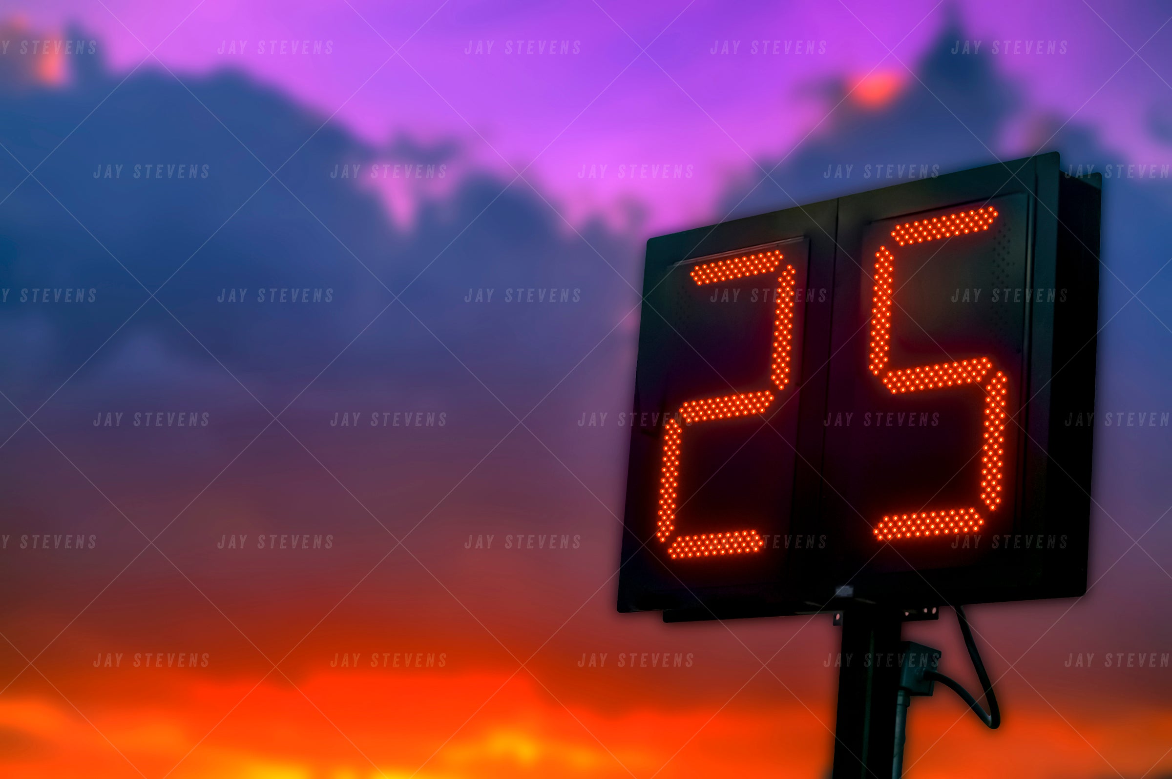 Digital clock displaying the number 25 against a colorful sky with purple and orange hues.
