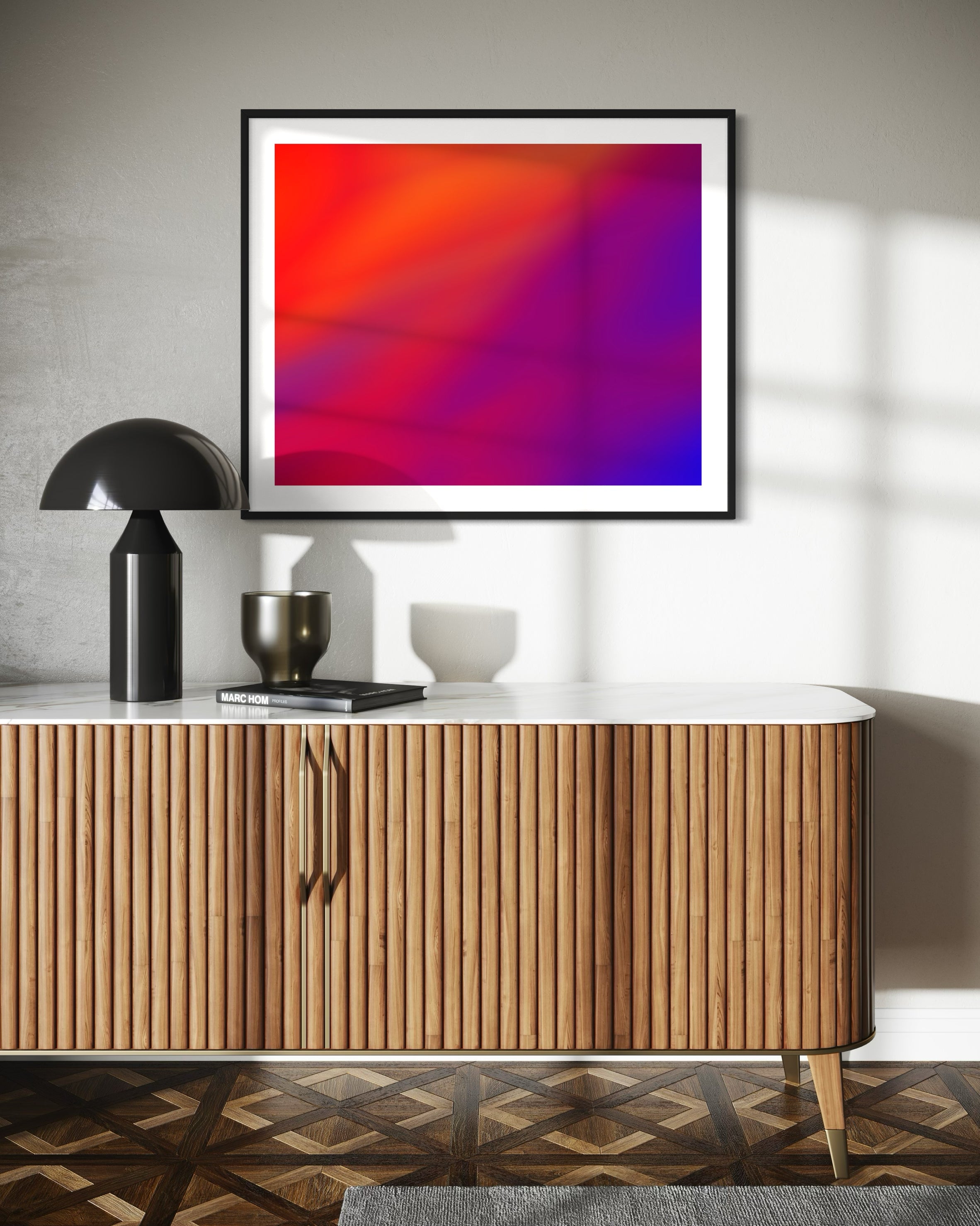 photo of abstract orange, yellow and purple in black frame with white matte on white wall above modern wood table with white top