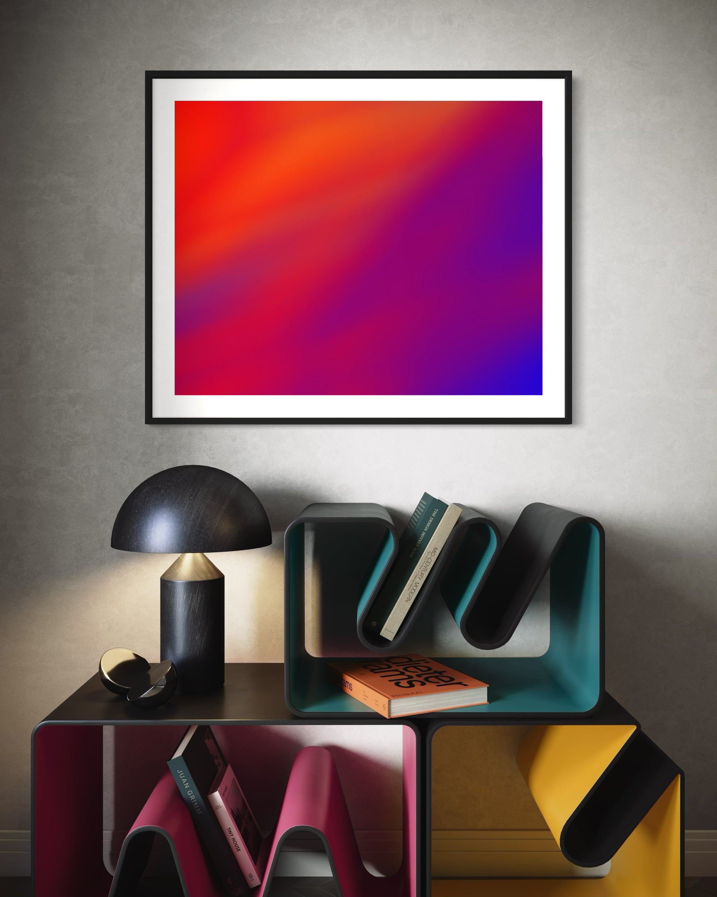 photo of abstract orange, yellow and purple in black frame on white brick wall above multi colored book racks in modern home