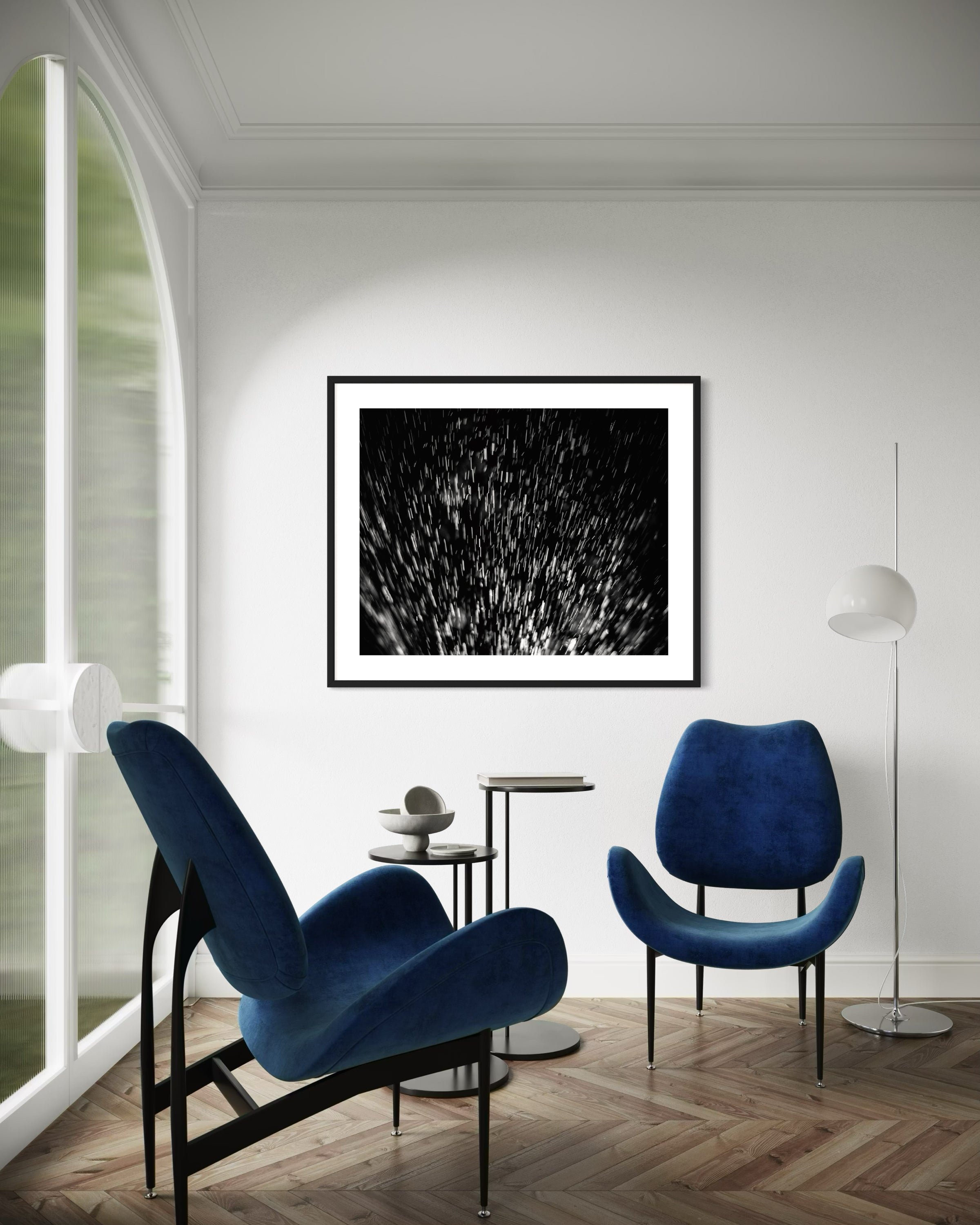 abstract water spray, backlit, spraying up, macro, black and white, photo art print in black frame on light gray wall in sitting area with 2 dark blue modern chairs on wood floor 