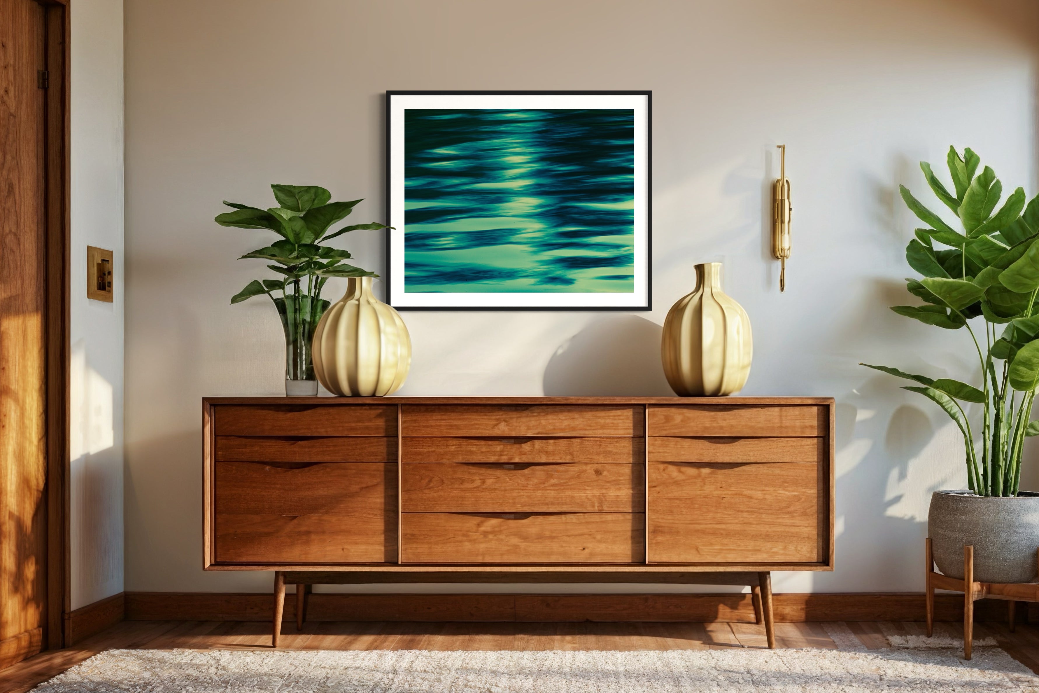 photo of abstract water in lake with blue, green and black in black frame with white matte on white wall in earthy room with green plants