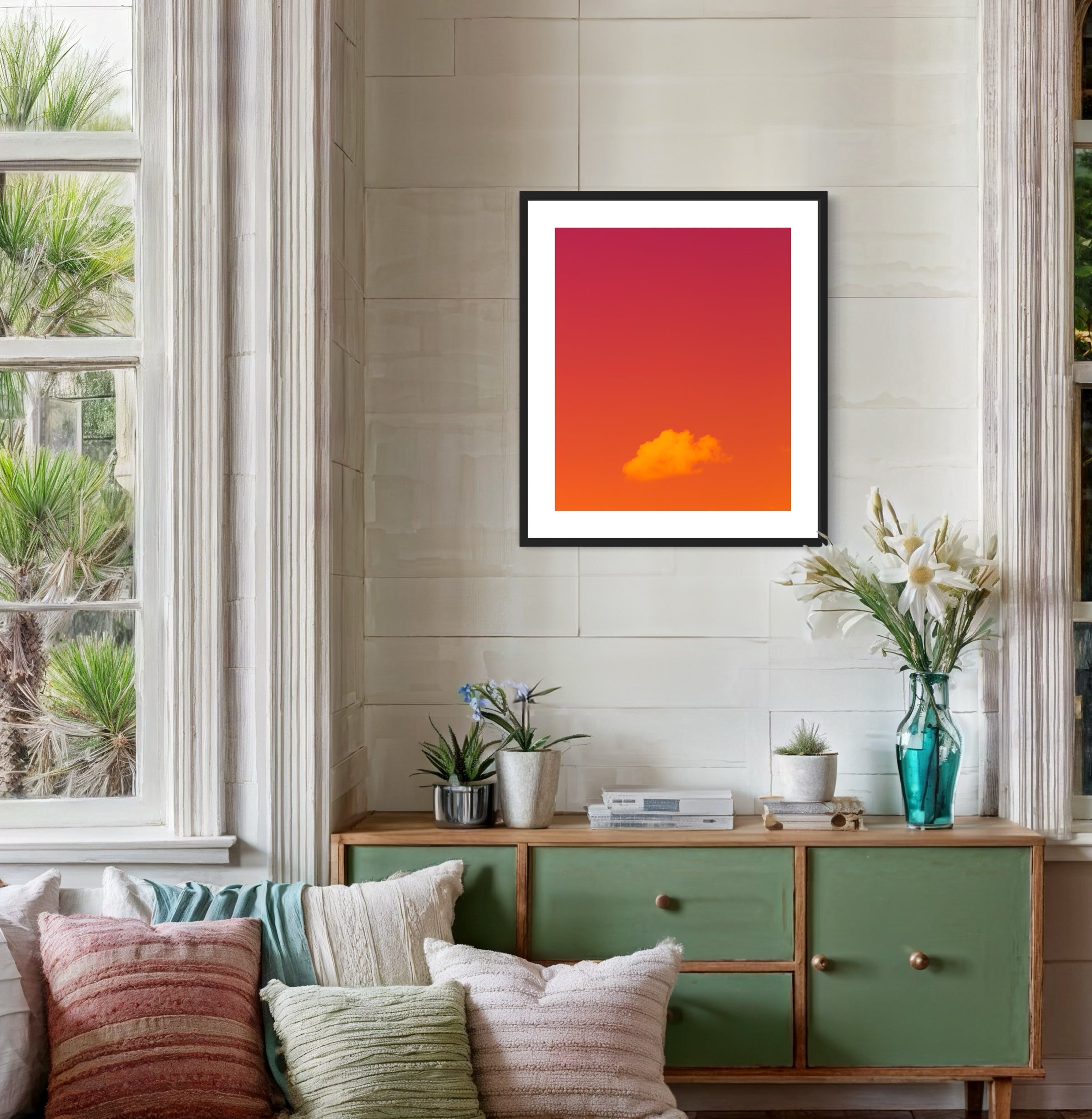 warm tone photo of single cloud in black frame with white matte on white wall in room with pastel tones