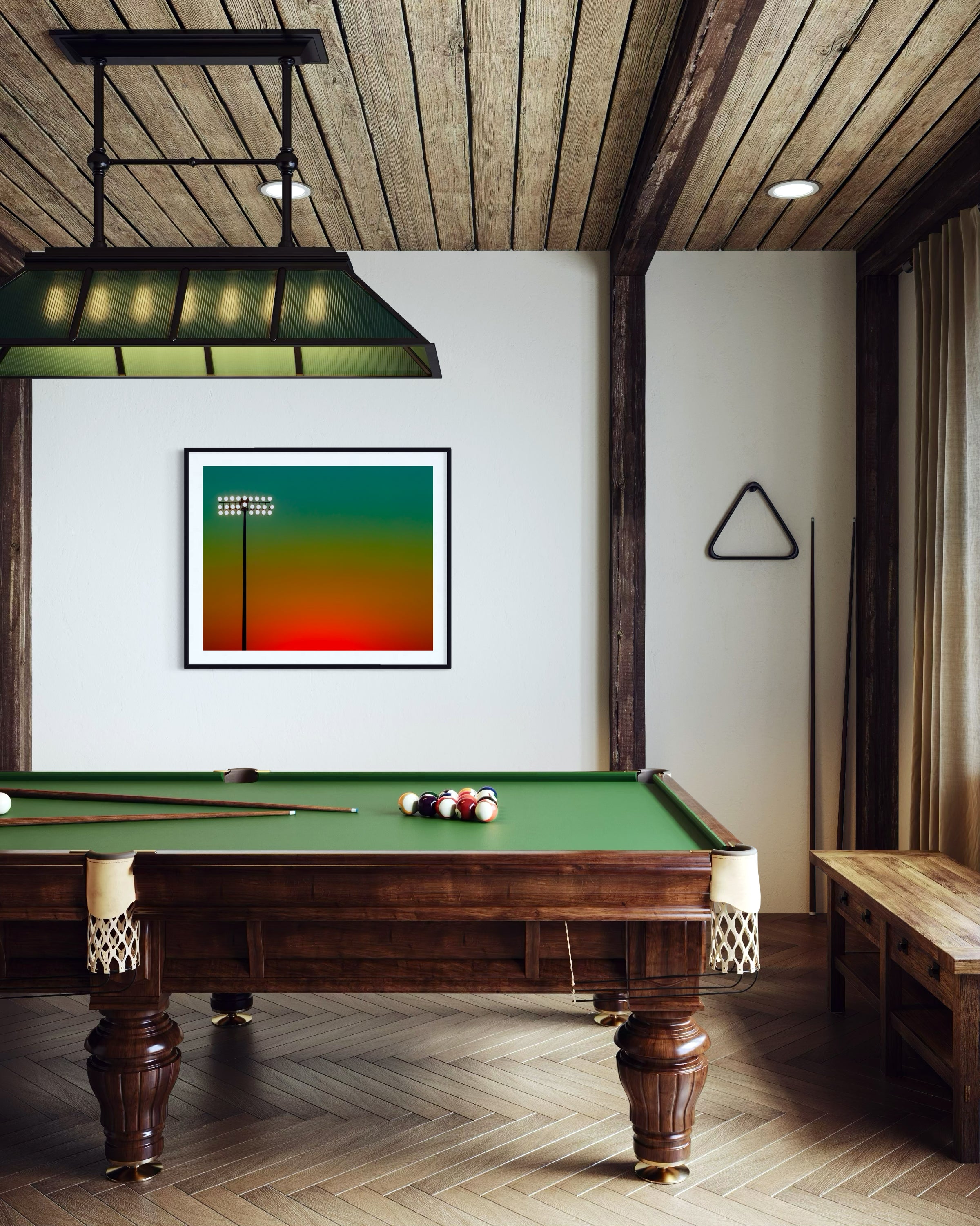 photo of sunset at football stadium single pole of lights left of center, gradient sky teal blue to pale yellow to orange gradient top to bottom in black frame with white matte on white wall in rustic game room with pool table