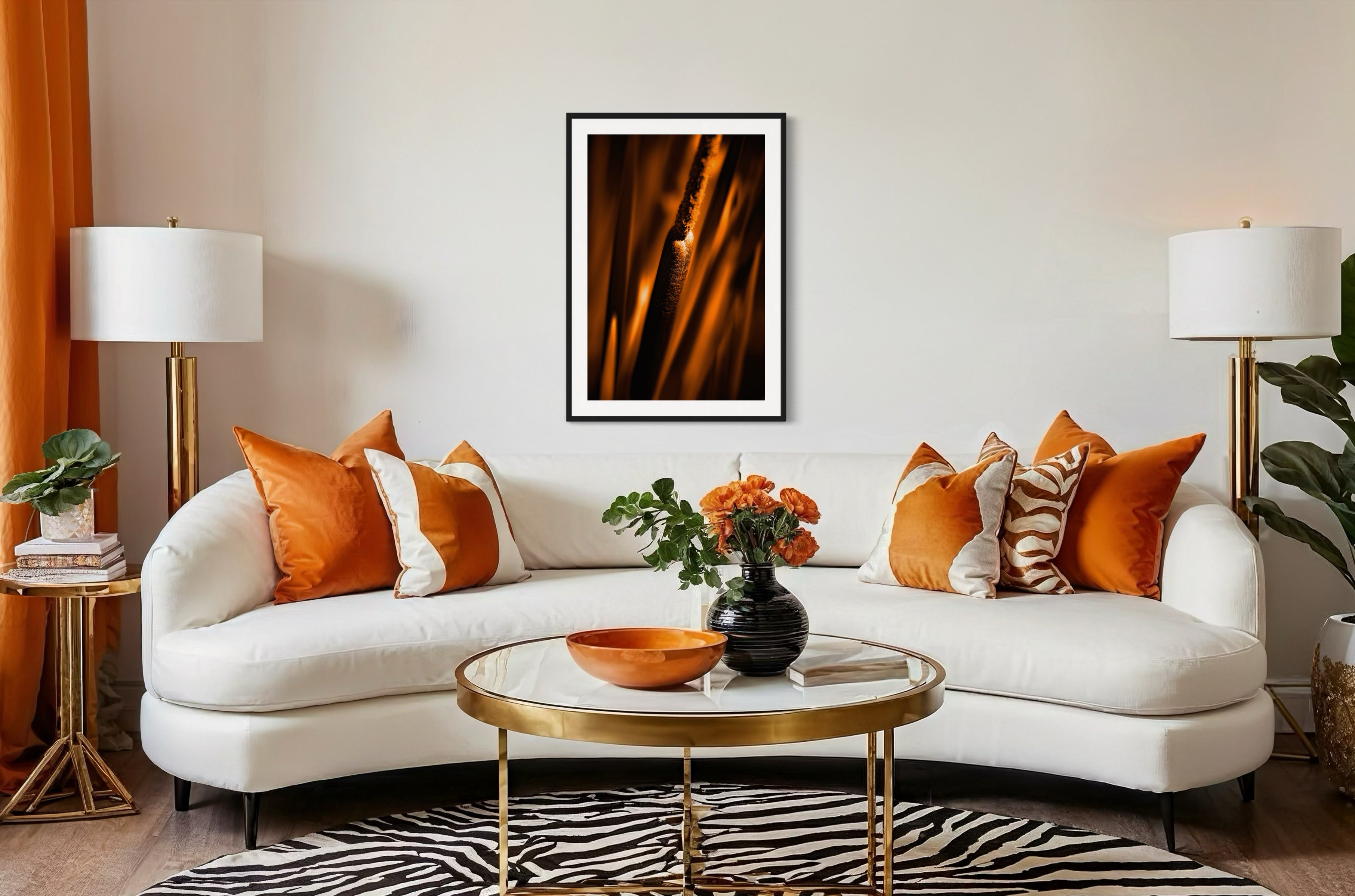reeds in gold tone with selective focus photo in black frame with white matte on white wall above curved white couch in living room with orange and white tones