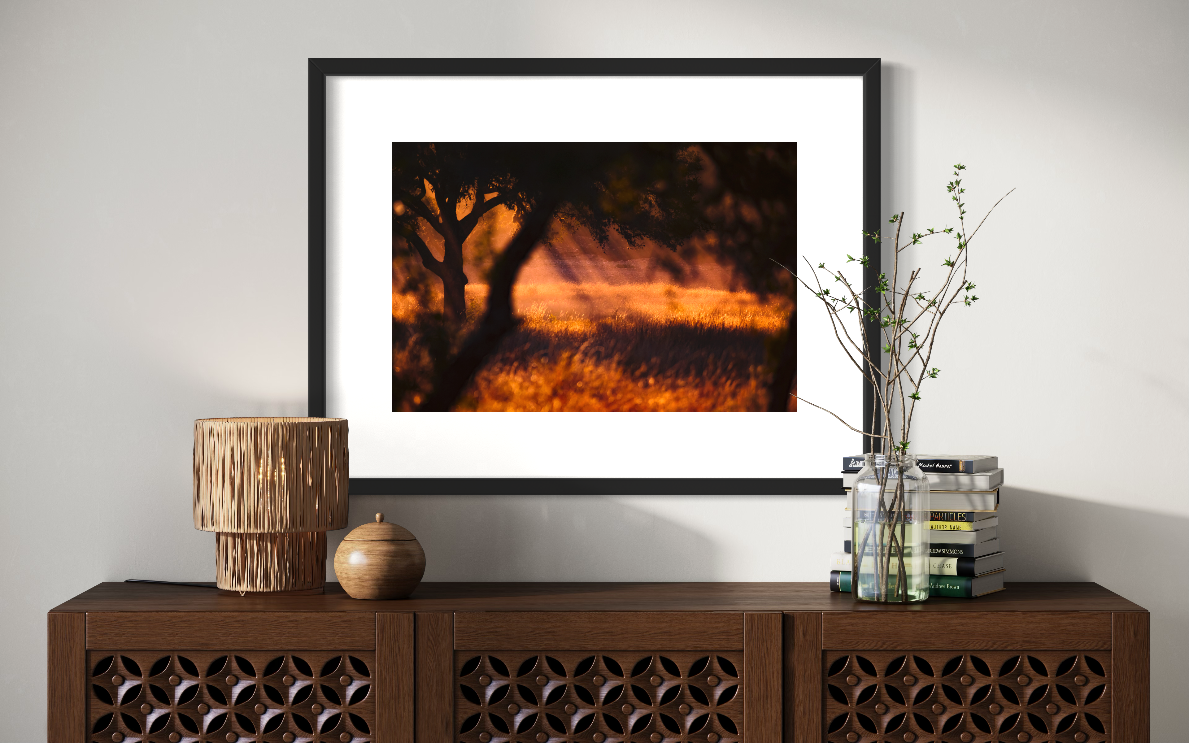 photo of rays of sunlight through the trees in black frame above modern brown piece of furniture