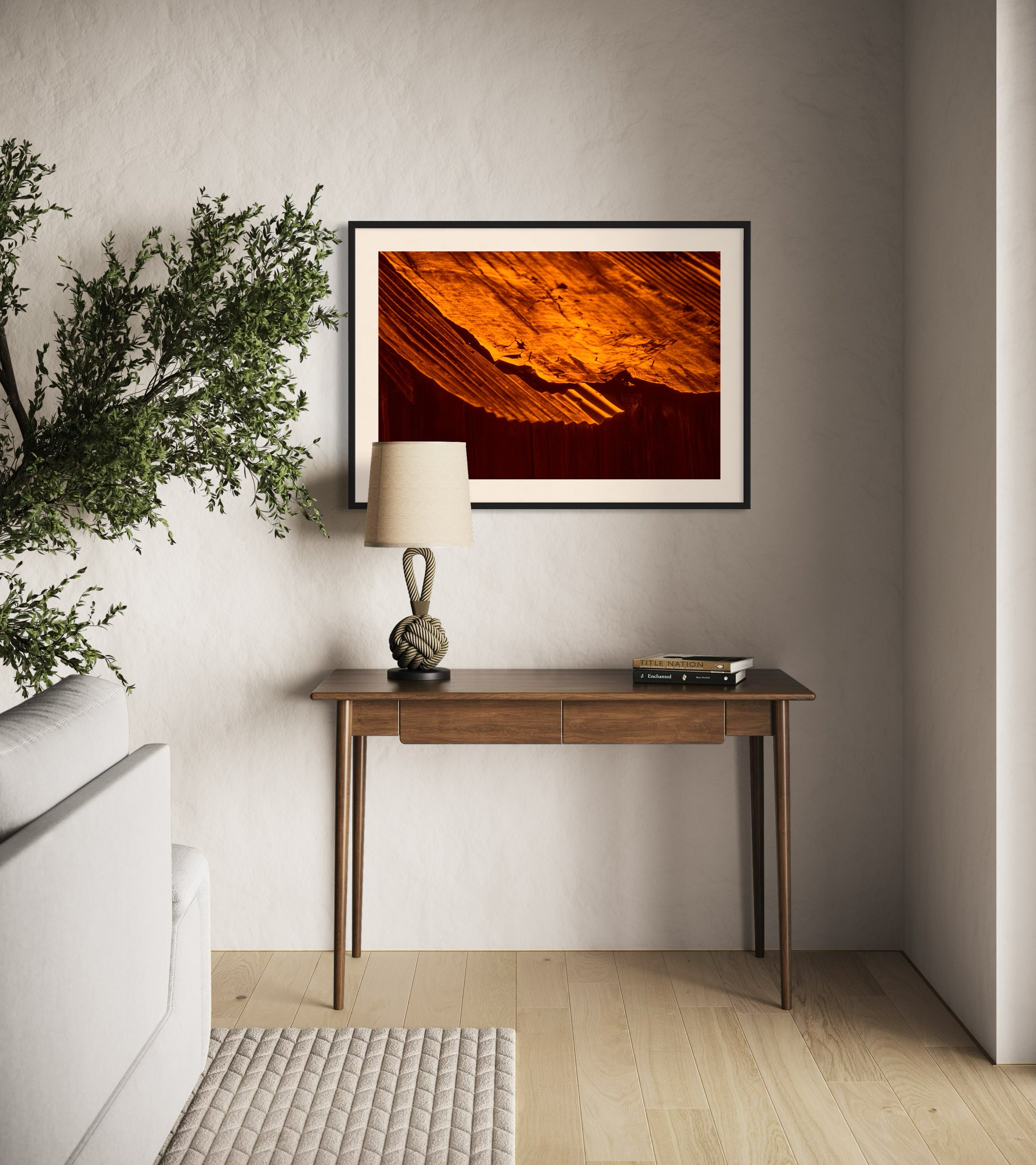 rusty old metal roof on old barn with warm tones photo in black frame on with off white matte on light tan wall above small wooden table in rustic home