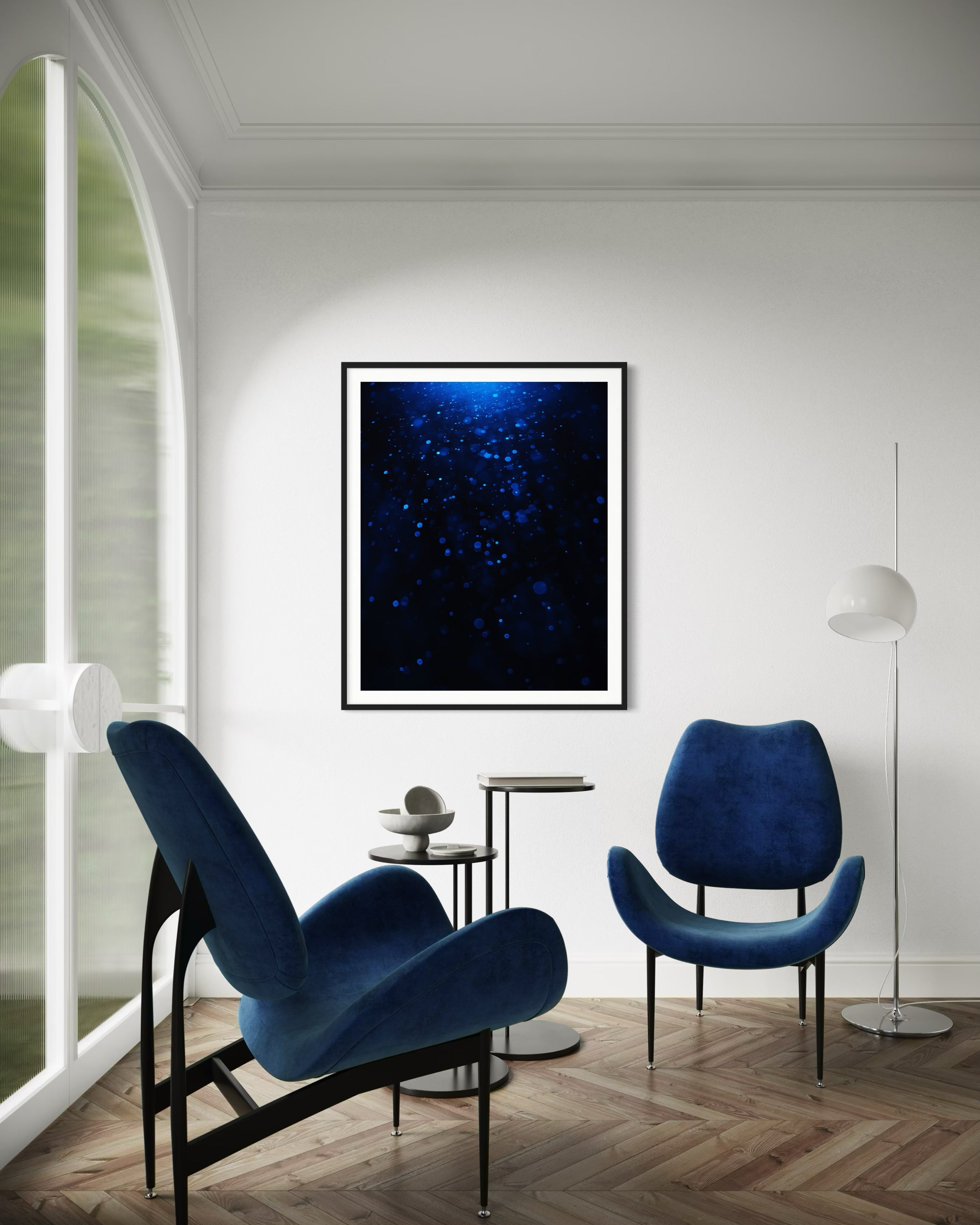 sci fi space looking photo as if close to the exterior of a space ship, blue tone, in black frame with white matte on off white wall modern sitting area with two blue chairs and a globe standing lamp