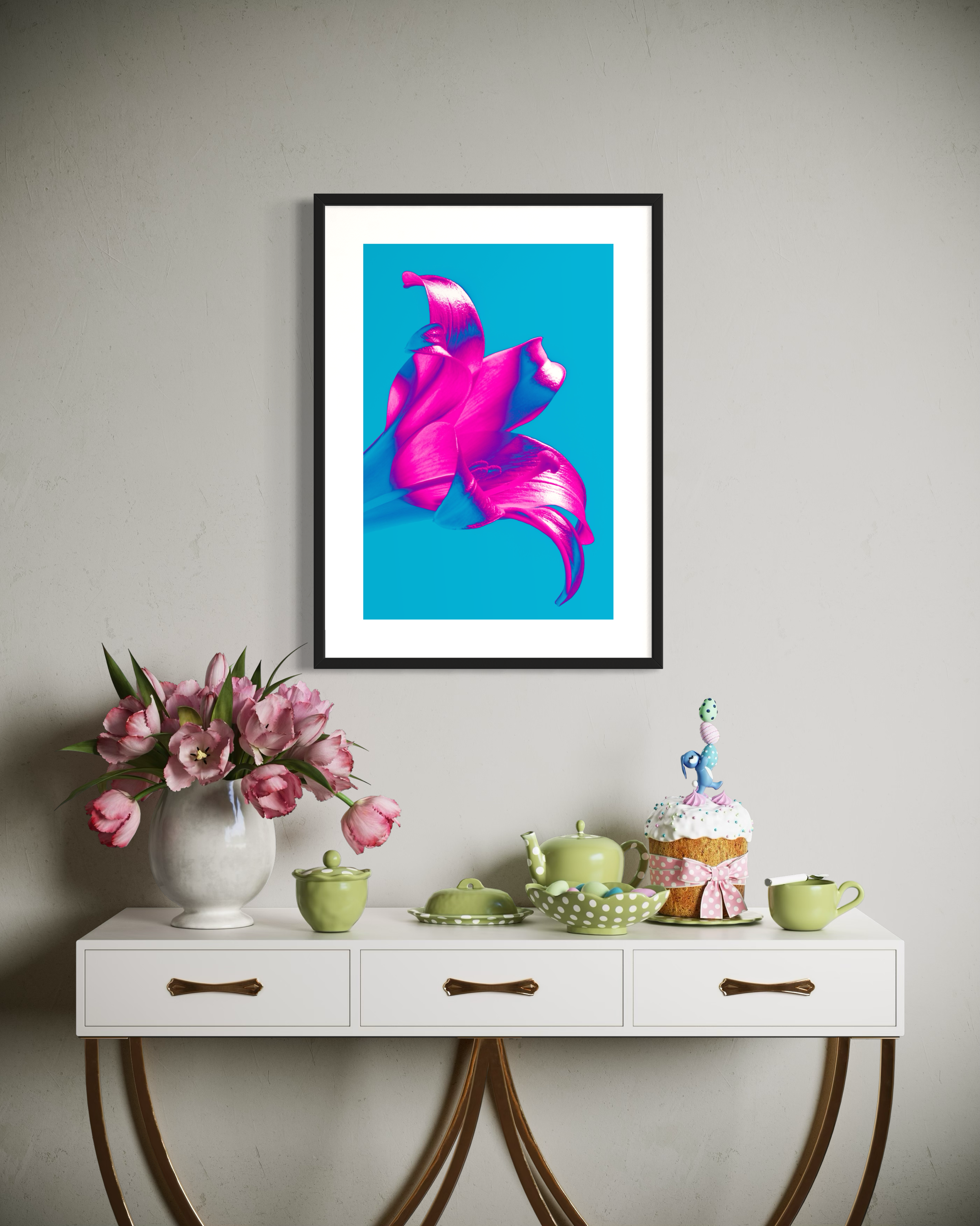 bright pop art photo of pink lily on blue background in black frame above small blue table with flowers, tea set and small, tall cake