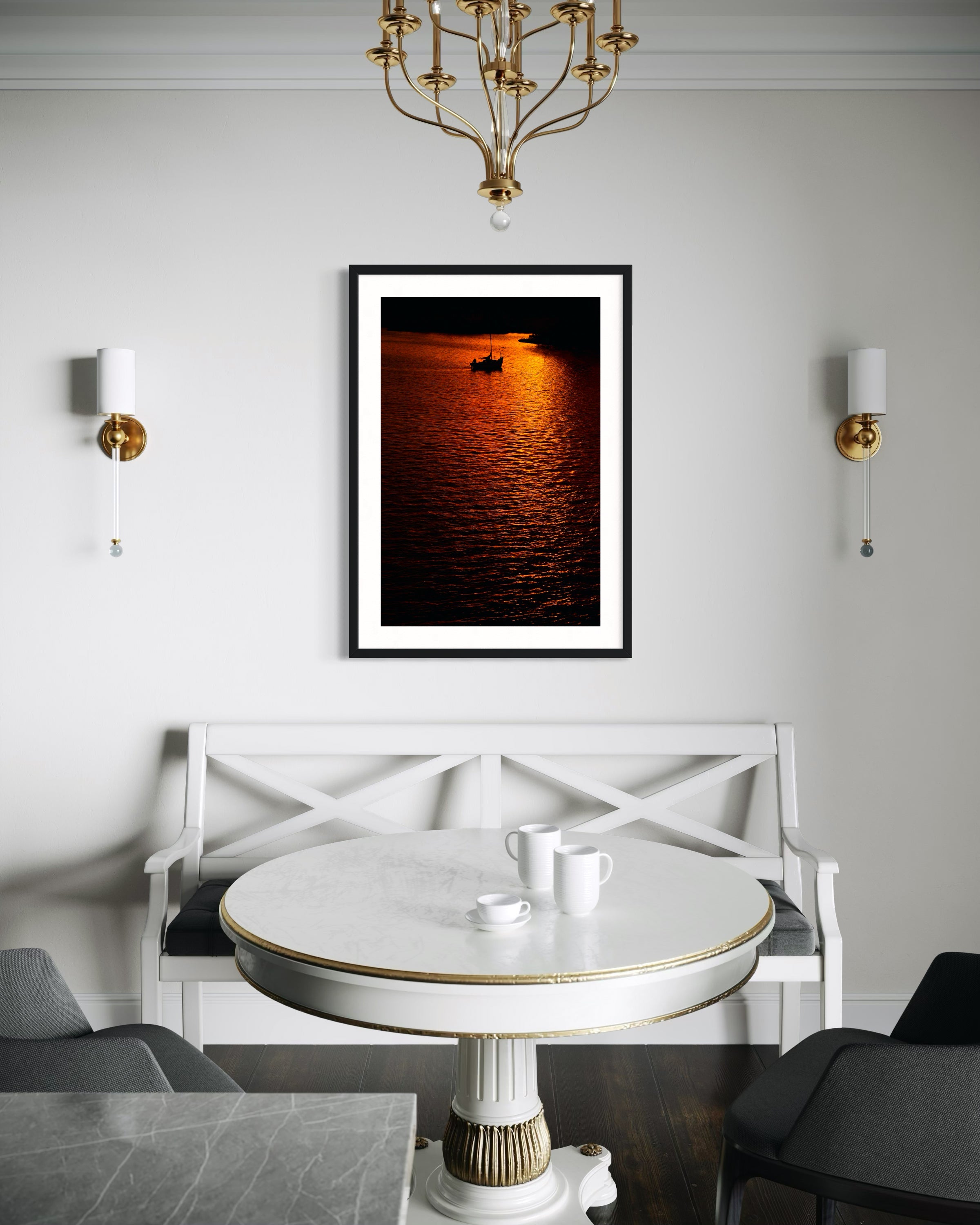 photo of sailboat sailing at sunset, in a very warm tone in black frame with white matte on white wall above white bench in modern sitting room