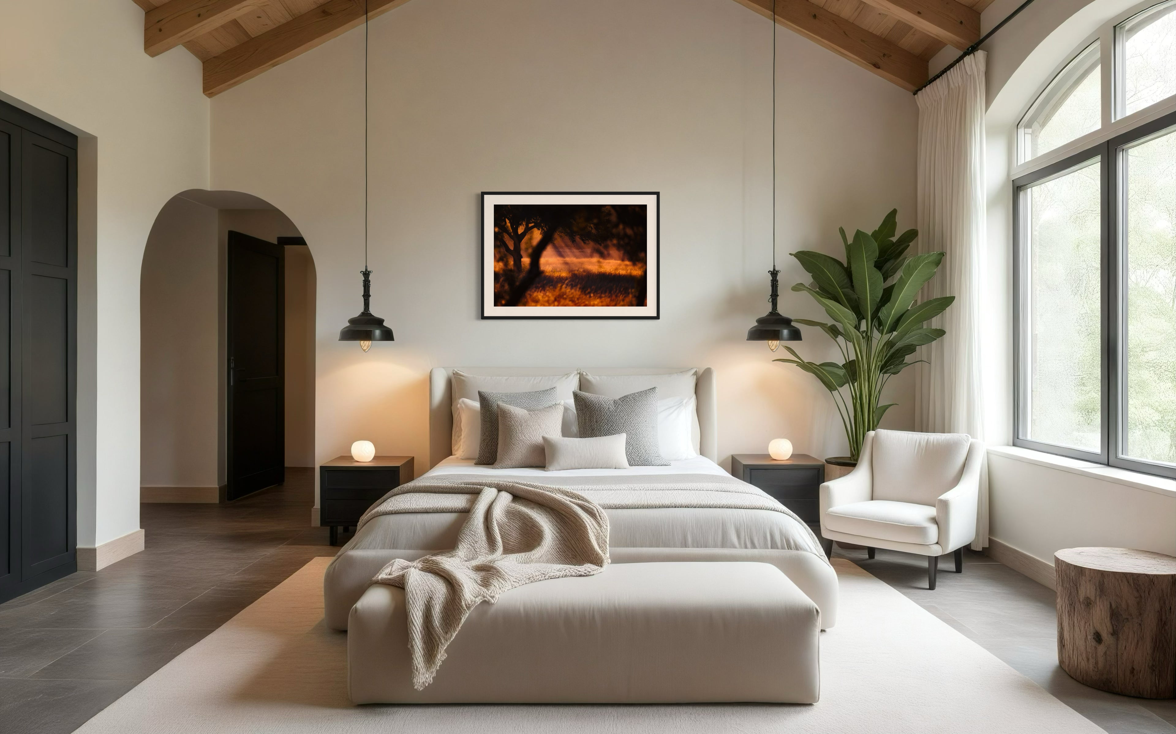 photo of rays of sunlight through the trees in black frame with off white matte on off white wall above bed in luxury bedroom with gray tile floors and exposed beams in the ceiling