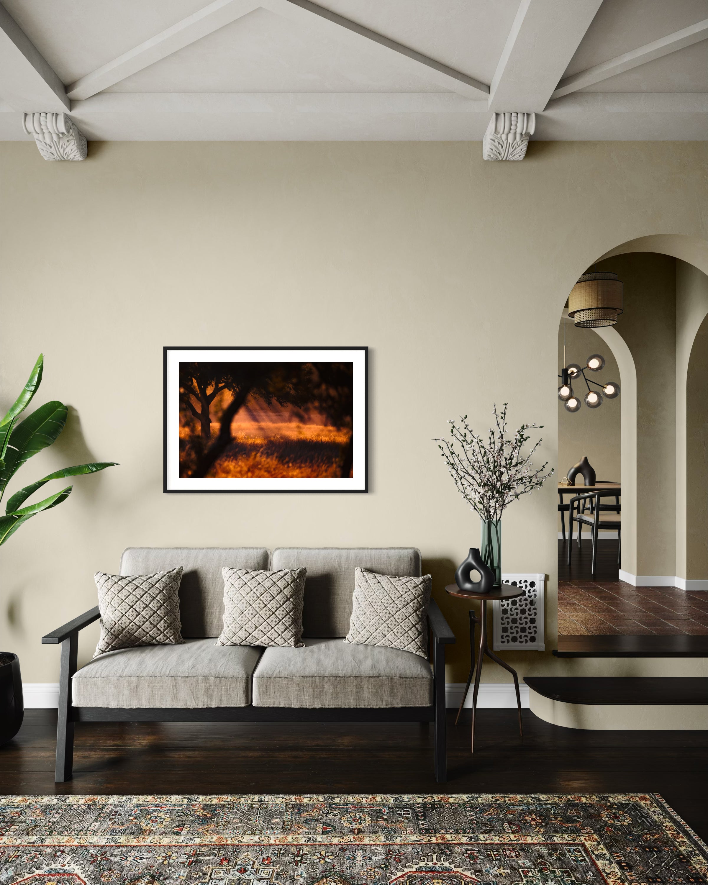 photo of rays of sunlight through the trees in black frame with off white matte on off white wall above gray couch in living room of Mediterranean style home