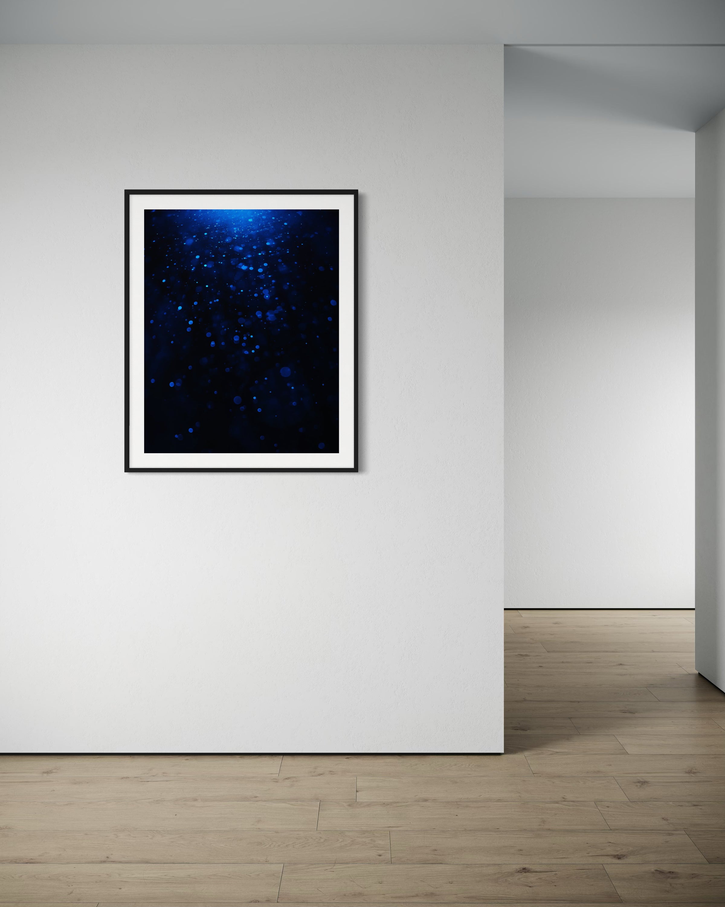 sci fi space looking photo as if close to the exterior of a space ship, blue tone, in black frame with white matte on off white wall in very minimalist room with blank walls and nothing on the hardwood floors
