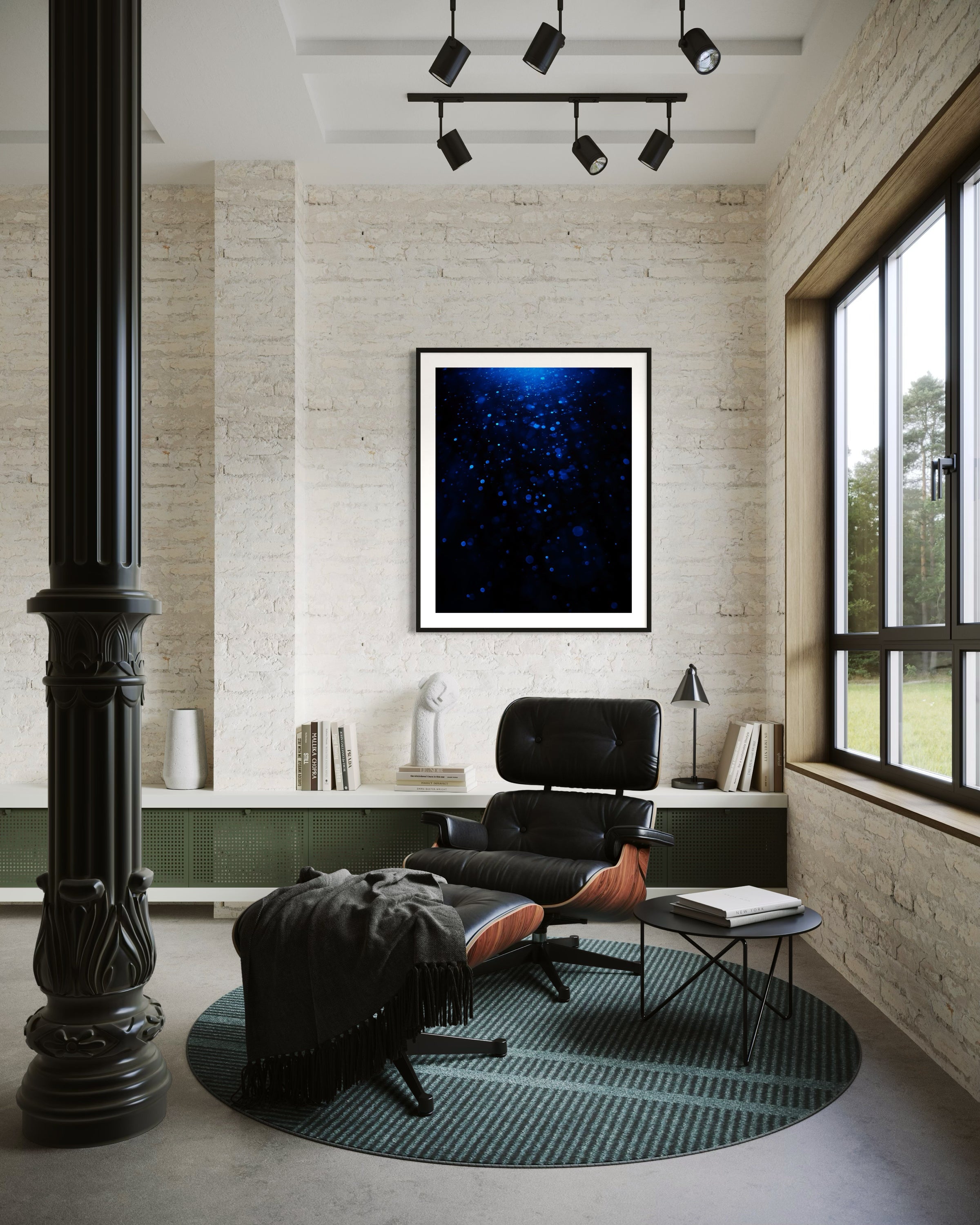 Modern office with black chair, round rug, and framed artwork on a brick wall.