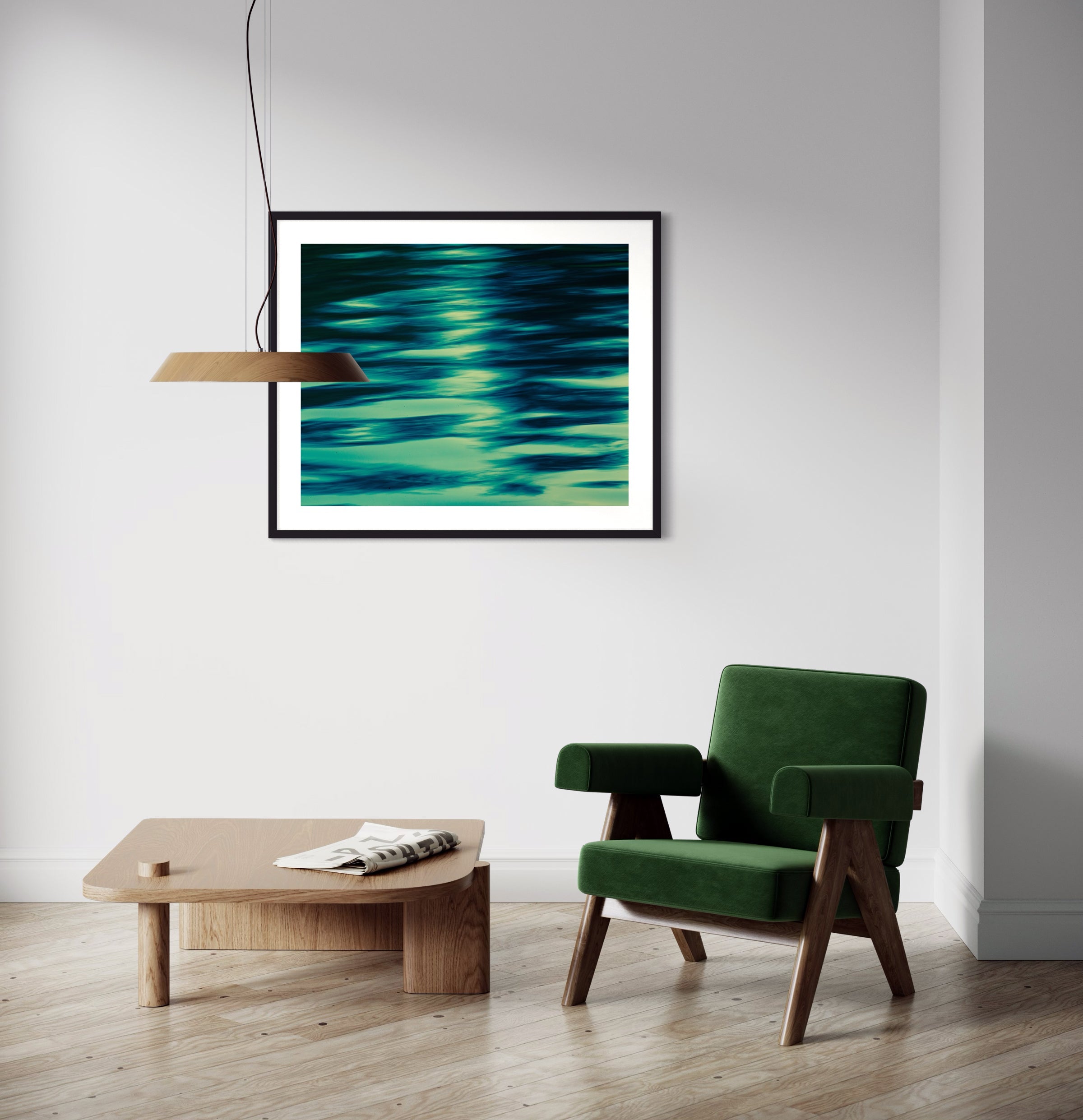 photo of abstract water in lake with blue, green and black in black frame with white matte on off white wall above small table and chair