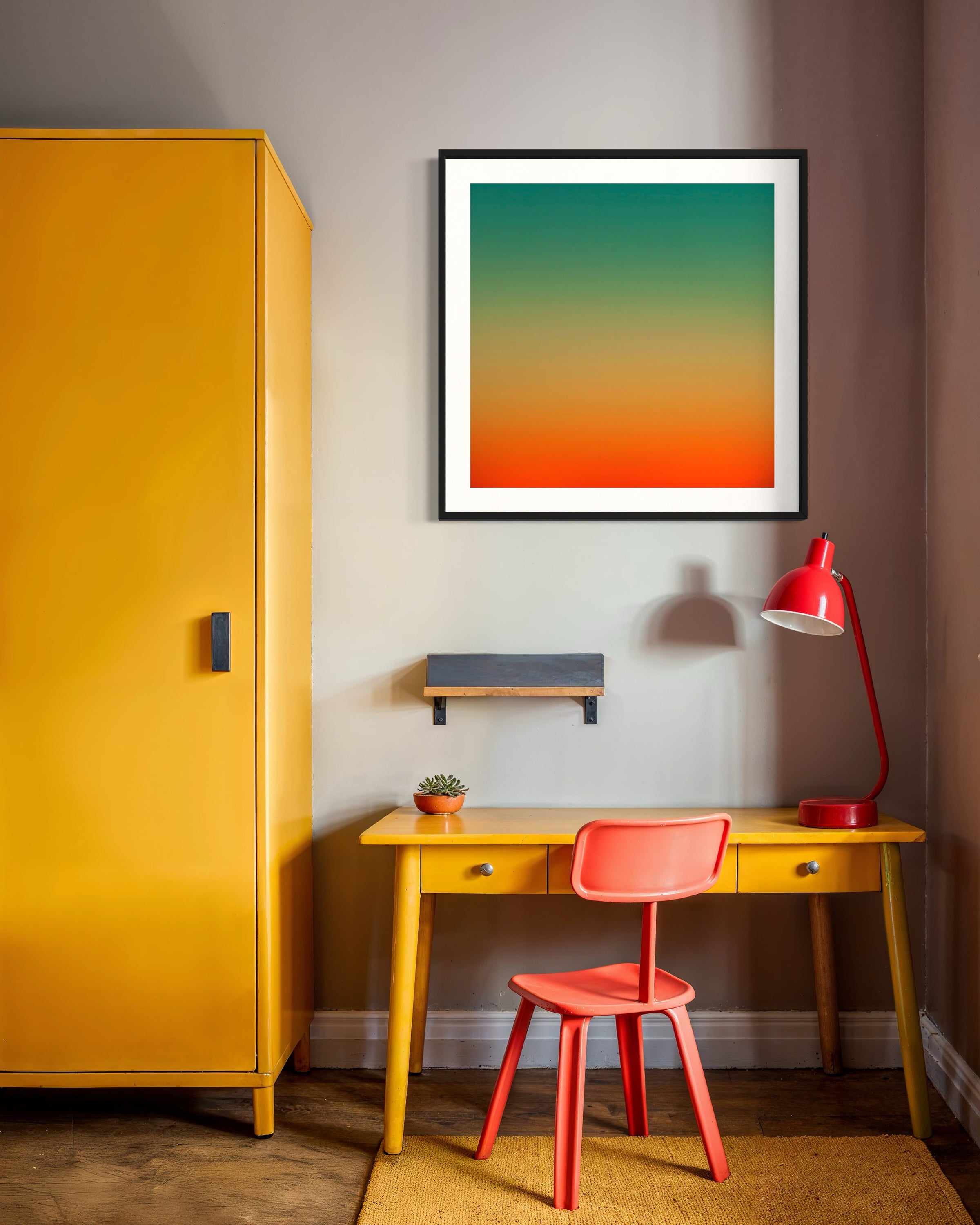 Colorful abstract art on a wall above a yellow desk with a red chair and lamp.