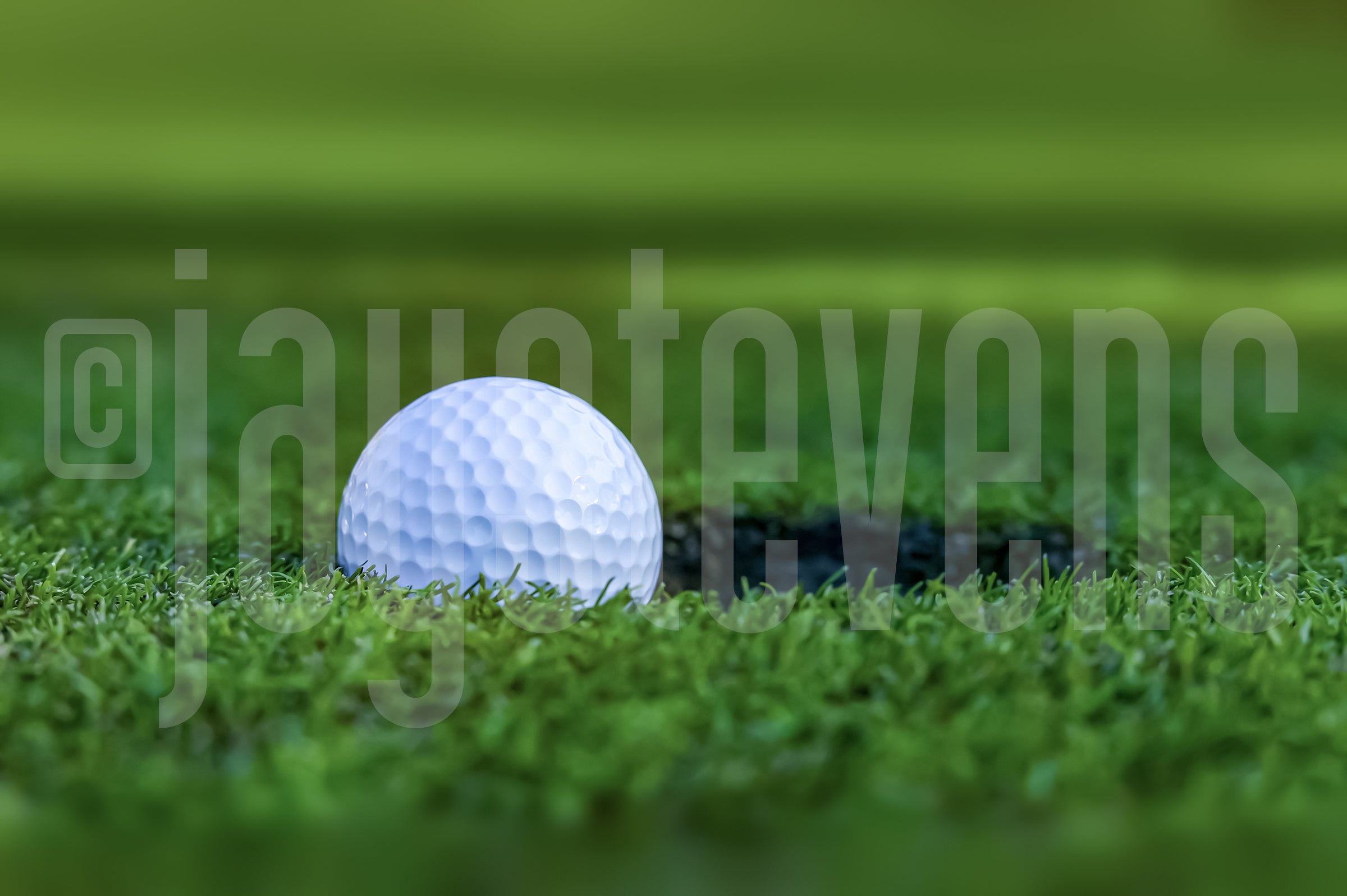 White golf ball on a green grass surface with a blurred background