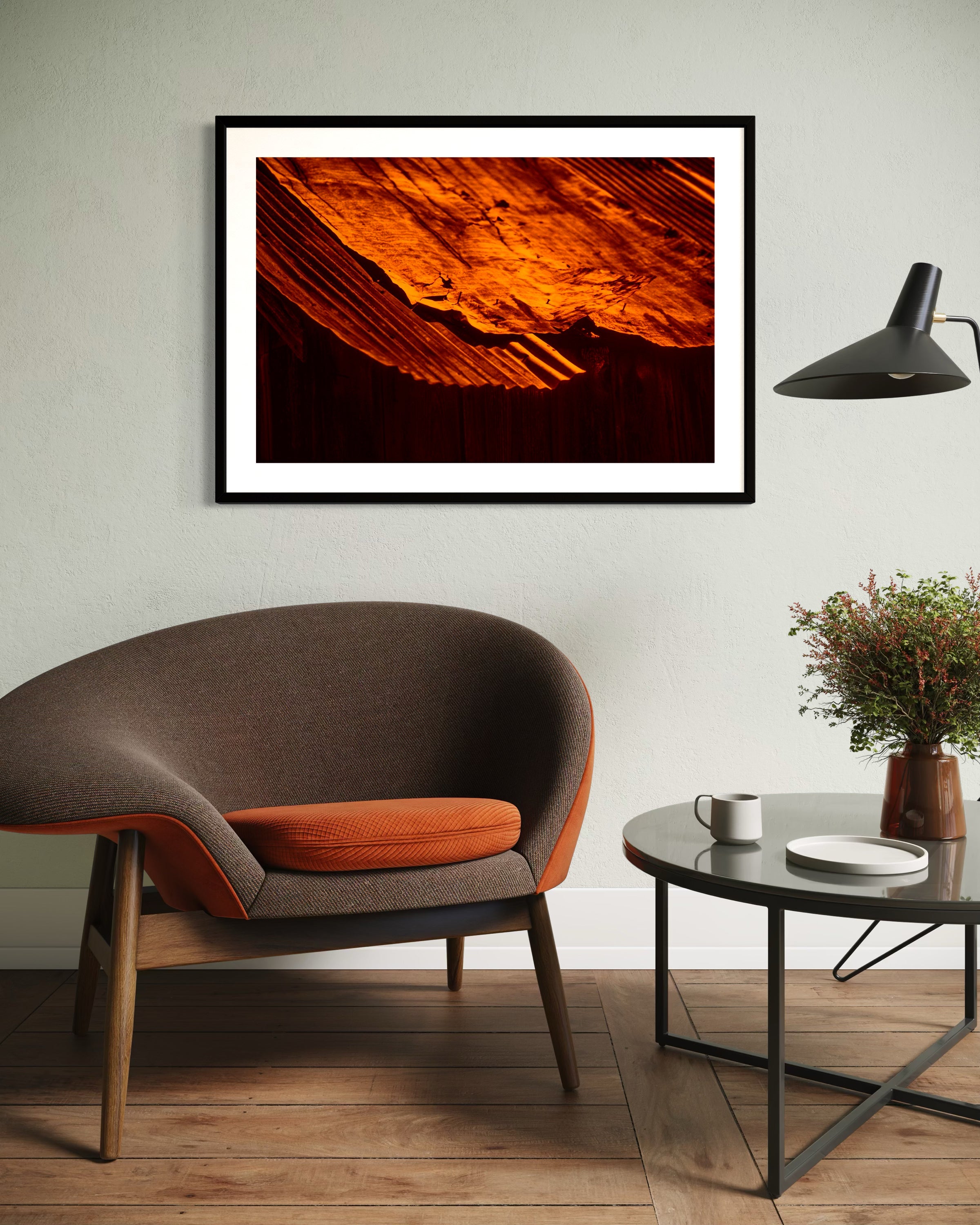 Modern living room with a framed artwork, brown chair, and coffee table.