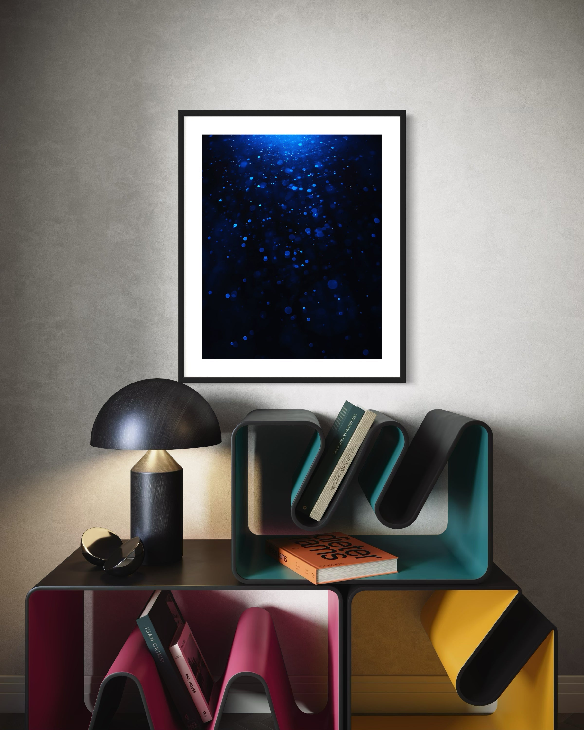 sci fi space looking photo as if close to the exterior of a space ship, blue tone, on off white wall above funky  multi colored small table/book storage